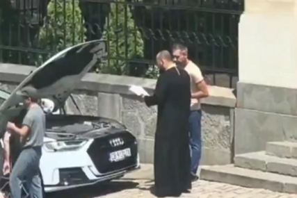(VIDEO) Blagoslov umjesto popravke: Sveštenik izašao iz crkve, pa PRIŠAO AUTU sa podignutom haubom i OČITAO MOLITVU, snimak nasmijao region