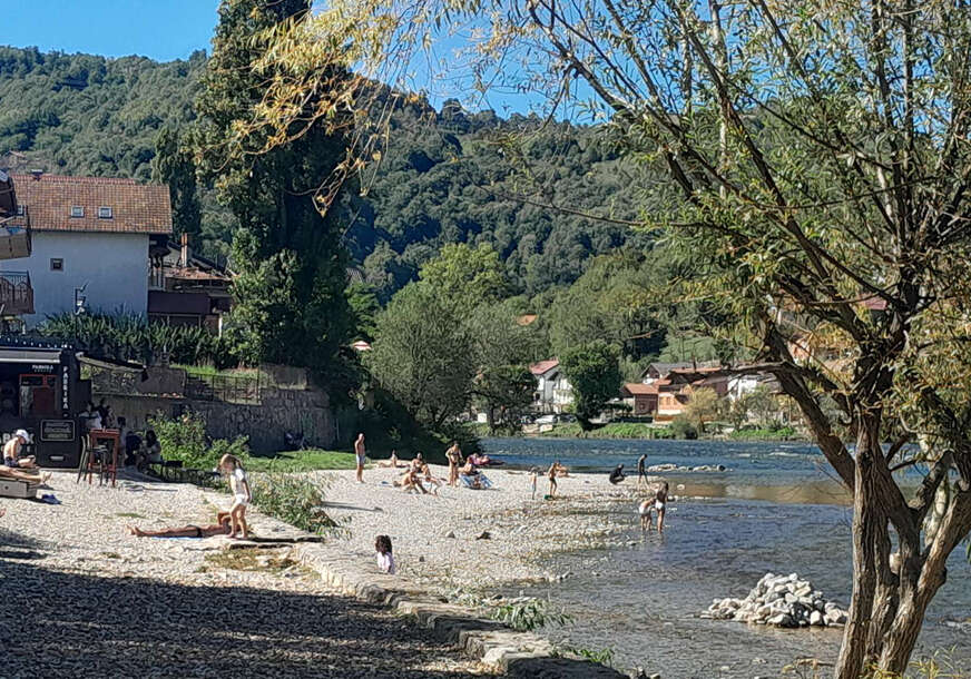 Ljudi se sunčaju uz rijeku