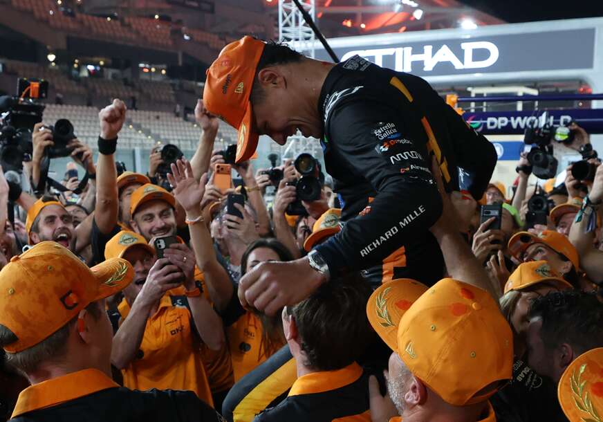 Lando Noris na rukama članova ekipe Meklarena