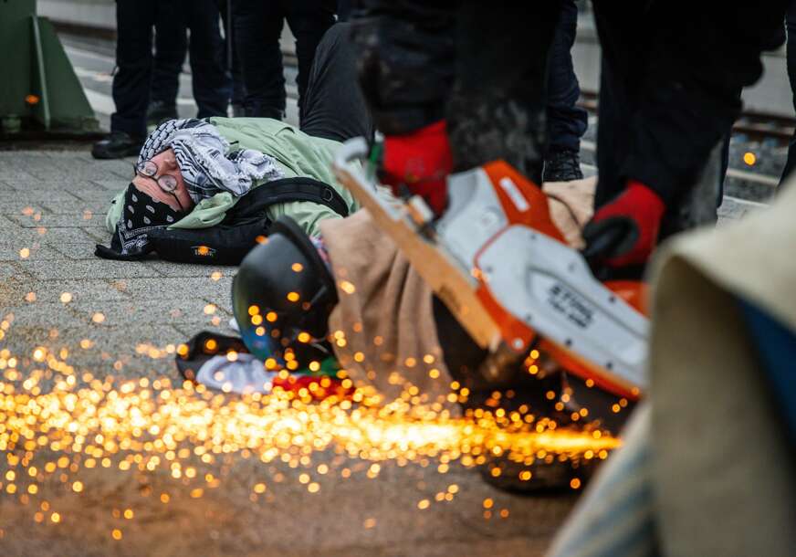 (VIDEO, FOTO) Obustavljen saobraćaj u Hagu: Aktivisti se VEZALI LANCIMA ZA PRUGU, pa skinuti uz pomoć brusilice