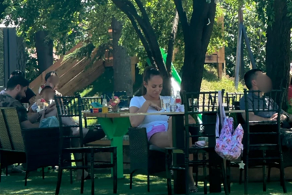 OD MARKA NI TRAGA Luna Đogani u opuštenom izdanju, sjedi na klupi dok se djeca igraju